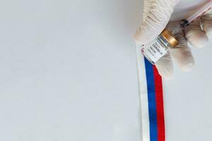 a person in white gloves holding a syringe photo