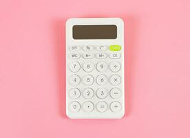 flat lay of white  calculator on pink background with copy space. photo