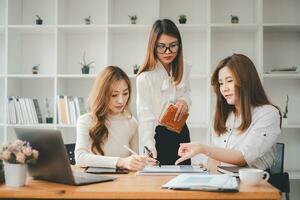 hembra operaciones gerente sostiene reunión presentación para un equipo de economistas asiático mujer usos negocio papel con crecimiento análisis, gráficos, Estadísticas y datos. foto