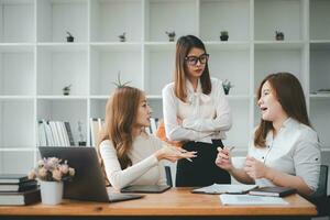 Serious team of professionals, Three multi ethnic business people negotiating in modern boardroom, discuss project, consider contract terms and conditions, solve business. photo