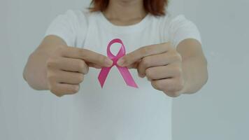 vrouw houden roze lint borst kanker bewustzijn. vrouw Gezondheid controleren bewustzijn. Internationale Dames dag en wereld kanker dag. teken kanker, symbolisch, Gezondheid zorg, ondersteuning patiënten, tijdig diagnose video