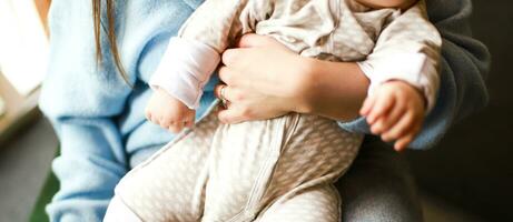 Banner Mom is holding a baby in her arms. Baby in cotton overalls photo