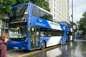 Gorgeous Low Angle view of Bus Service and British Traffic at Central London City of England UK. Image Captured on August 2nd, 2023 During Cloudy and Rainy Day. photo