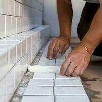 Builder puts white tiles on stairs photo