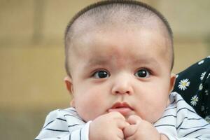 Cute Asian Pakistani Baby Boy is Posing in the Home Garden During Cloudy Day over Luton, England UK. Image Was Captured on July 23rd, 2023 photo