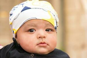 Close Up Shot of Cute Asian Pakistani 4 Months Old Baby Boy, Who is Enjoying at Home Garden at Luton City of England UK. Image Was Captured on July 23rd, 2023 photo