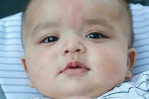 Cute Asian Pakistani Baby Boy is Posing in the Home Garden During Cloudy Day over Luton, England UK. Image Was Captured on July 23rd, 2023 photo