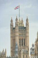 Beautiful Low Angle View of Historical Big Ben Clock Tower from river Thames and London Eye, Westminster Central London, England Great Britain, UK. Image Captured During Cloudy Day of August 2nd, 2023 photo