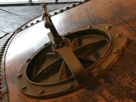 Metallic manhole cover and an industrial construction close view photo