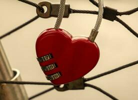 corazón bloquear a el puente, rojo corazón bloquear con un código, amor y pasión foto. un contraseña desde mi corazón concepto foto