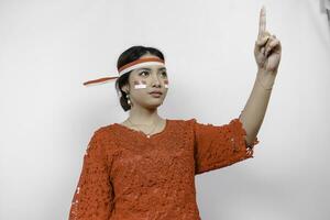 Young woman speaker wearing red kebaya and headband gesturing oration with hands isolated on white background. Indonesia's independence day concept. photo