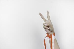 hands gesturing signs of number wearing Indonesian red and white ribbon. Indonesia's independence day concept photo