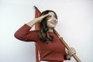 indonesio mujer dar saludo con orgulloso gesto mientras participación de indonesia bandera. de indonesia independencia día concepto. foto