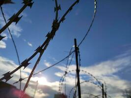 Barbed twisted wire metal fence close view photo