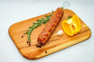 Tasty sausages and vegetables isolated over solid background photo