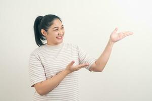 mujer asiática con la mano presentando en el fondo de la pared foto