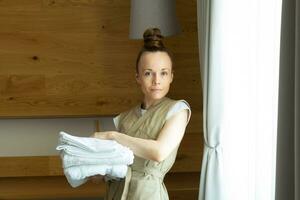 a woman holding a stack of towels photo