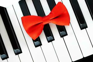 a red bow tie on the keys of a piano photo