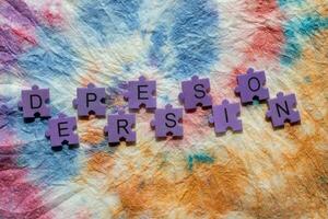 depression word puzzle on colorful tie dye background photo