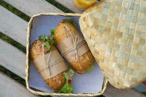 sandwiches in a basket on a picnic table photo