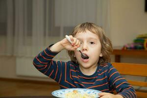 a young boy eating cereal photo