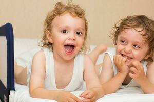 two young children laying on a bed photo