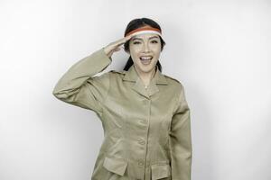 Proud government worker woman gesturing salute pose isolated by white background. PNS wearing khaki uniform. Indonesia's independence day concept. photo