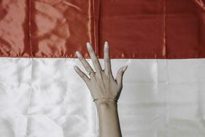 Hands gesturing signs of number isolated by Indonesian red and white flag. Indonesia's independence day concept photo