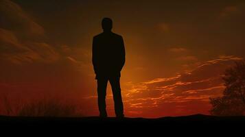 Man s silhouette in front of the setting sun photo