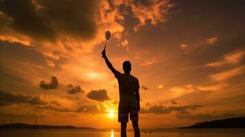 bádminton jugador s silueta durante dorado hora puesta de sol foto