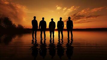 Men s silhouettes beside the lake during sunset photo