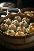 a bamboo plate of dumplings with sauce and garnish photo