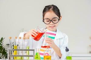 Asian little girl working with test tube science experiment in white classroom photo