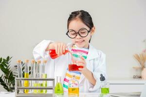 Asian little girl working with test tube science experiment in white classroom photo