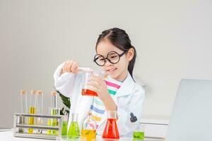 Asian little girl working with test tube science experiment in white classroom photo