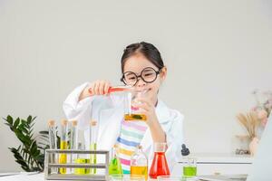Asian little girl working with test tube science experiment in white classroom photo