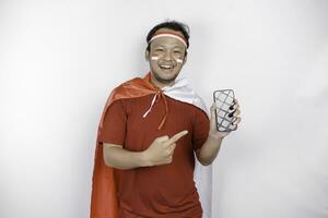 A portrait of a smiling Asian man wearing headband and showing his phone, isolated by white background. Indonesia's independence day concept photo