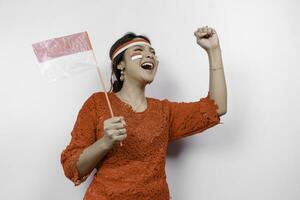 A young Asian woman with a happy successful expression wearing red kebaya and headband isolated by white background. Indonesia's independence day concept. photo