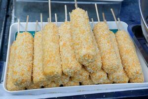 unfried corndogs sprinkled with panir flour or breadcrumbs and sold at culinary festivals. hotdog style Korean street food popular, in indonesia called Hotang photo