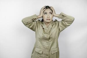 Mad civil worker woman wearing a brown uniform feeling so stressed. Indonesian government employees overworked concept. photo