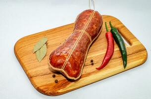 Tasty sausages and vegetables isolated over solid background photo