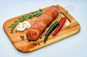 Tasty sausages and vegetables isolated over solid background photo