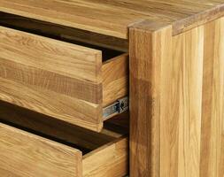 Opened wooden drawers with sliders close view photo, wooden eco furniture elements background. Solid wood furniture details photo