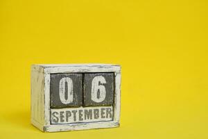 septiembre 06 de madera calendario en pie amarillo antecedentes con un vacío espacio para texto. foto