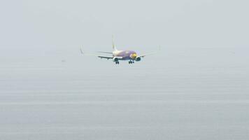 PHUKET, THAILAND NOVEMBER 27, 2017 - Commercial plane Boeing 737 of NOK Air landing at Phuket airport. Sea in the background. NOK Air company is the largest low cost airlines in Thailand video