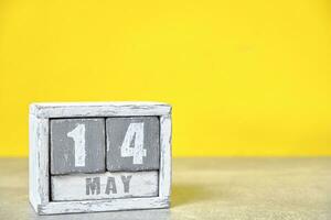 mayo 14 calendario hecho de madera cubitos amarillo fondo.con un vacío espacio para tu texto. foto