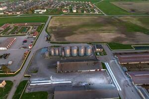 aerial panoramic view on agro-industrial complex with silos and grain drying line for drying cleaning and storage of cereal crops photo