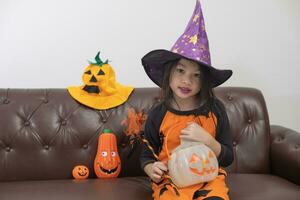 Happy asian child girl in witch costume to halloween photo