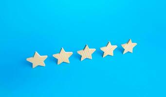 Five stars are in a row on a blue background. Rating evaluation concept. Popularity of restaurants, hotels or mobile applications. Service quality feedback. Great reputation. High satisfaction. photo
