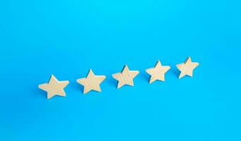 Five stars are in a row on a blue background. Rating evaluation concept. Popularity of restaurants, hotels or mobile applications. Service quality feedback. Great reputation. High satisfaction. photo